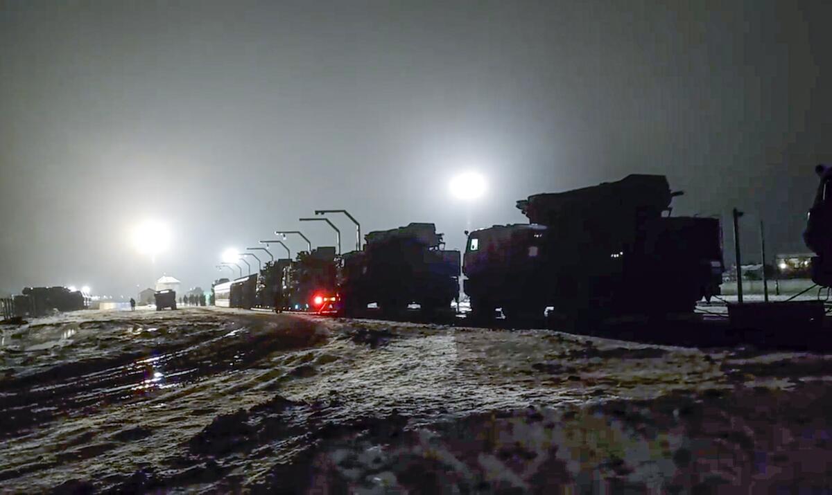 Russian military vehicles on a railway platform at night