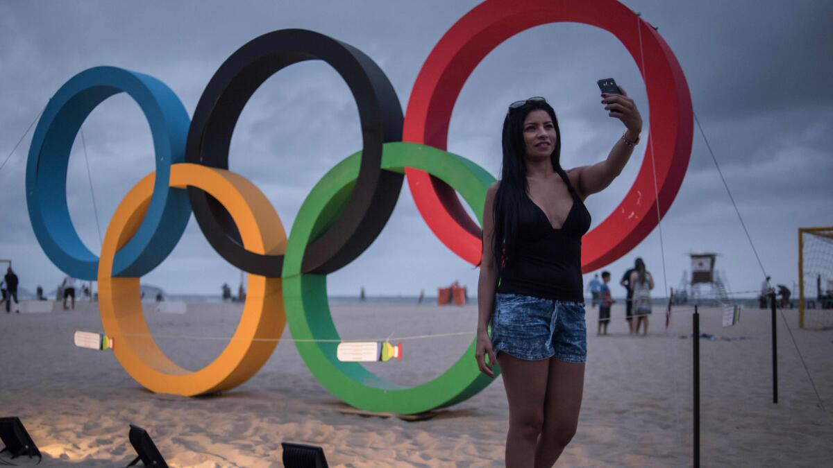 A woman takes a selfie in front of the Olympic rings at Copacabana beach in Rio de Janeiro on Saturday.