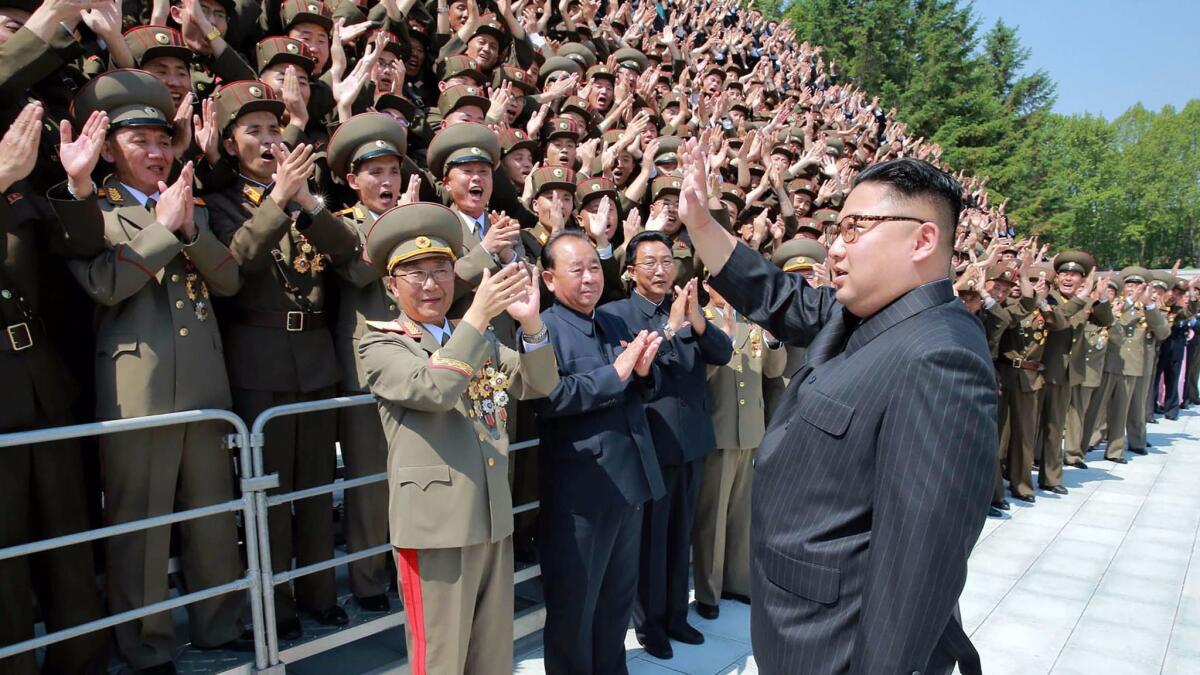 North Korean leader Kim Jong-un waves to developers of the medium- to long-range strategic ballistic rocket Hwasong-12 in Pyongyang.