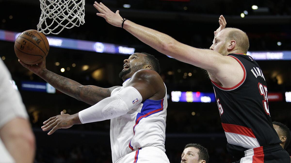 Clippers forward Glen Davis, left, puts up a shot in front of Portland Trail Blazers center Chris Kaman during the Clippers' loss at Staples Center on March 4.