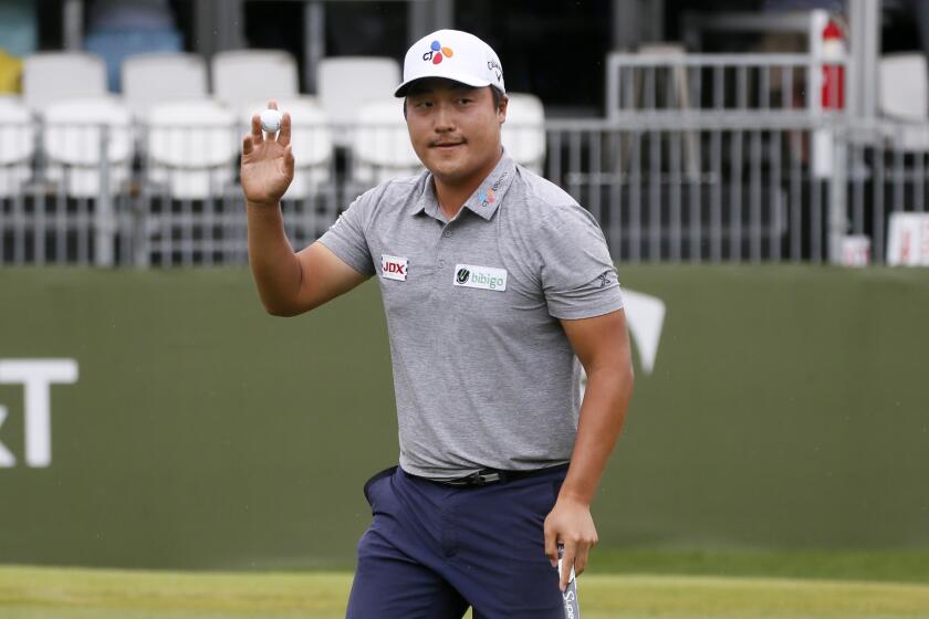 Kyoung-Hoon Lee, of South Korea, acknowledges applause from the gallery after his putt on the 17th green.