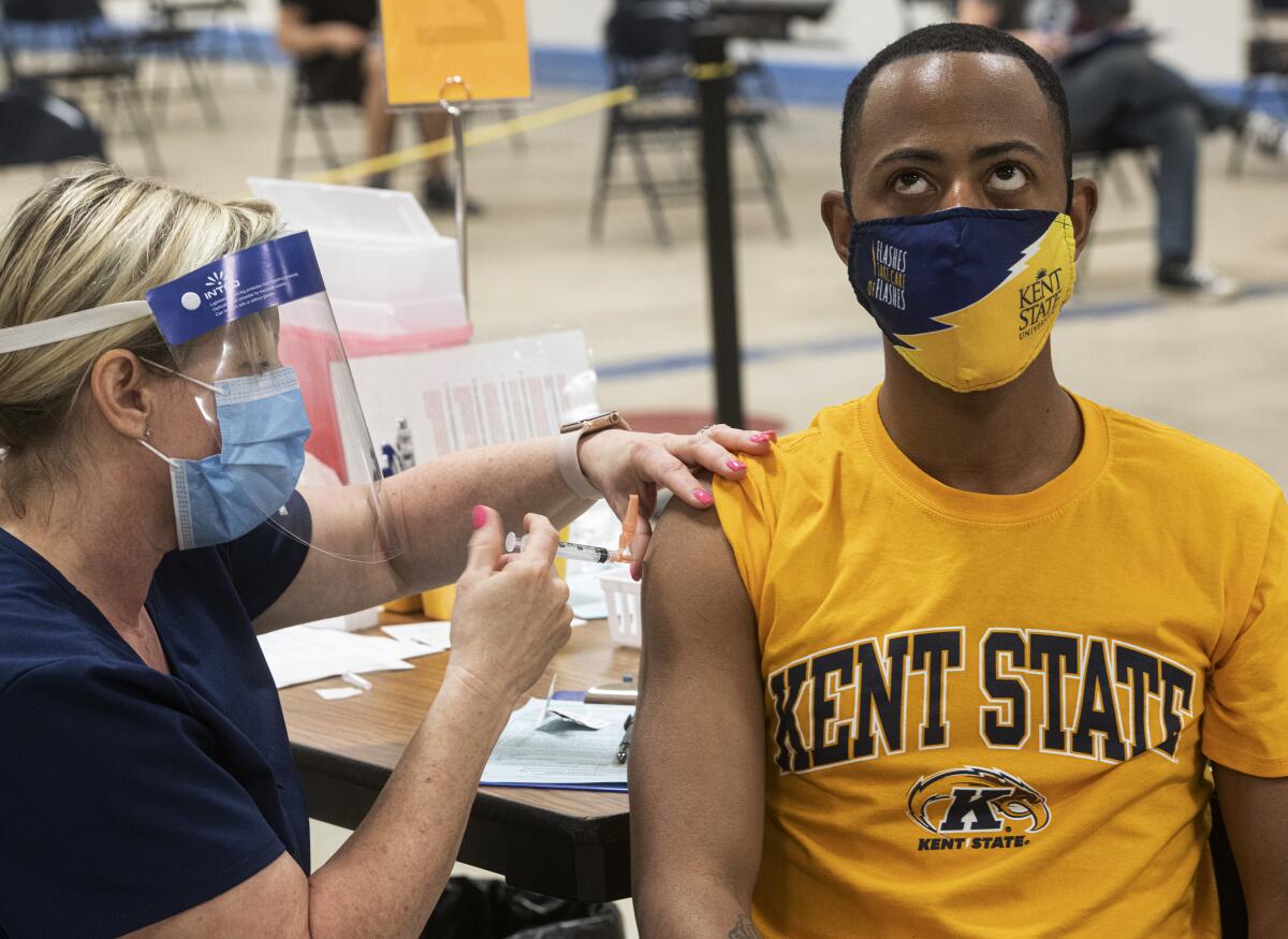 A Kent State University student bares his arm for a COVID-19 vaccination.