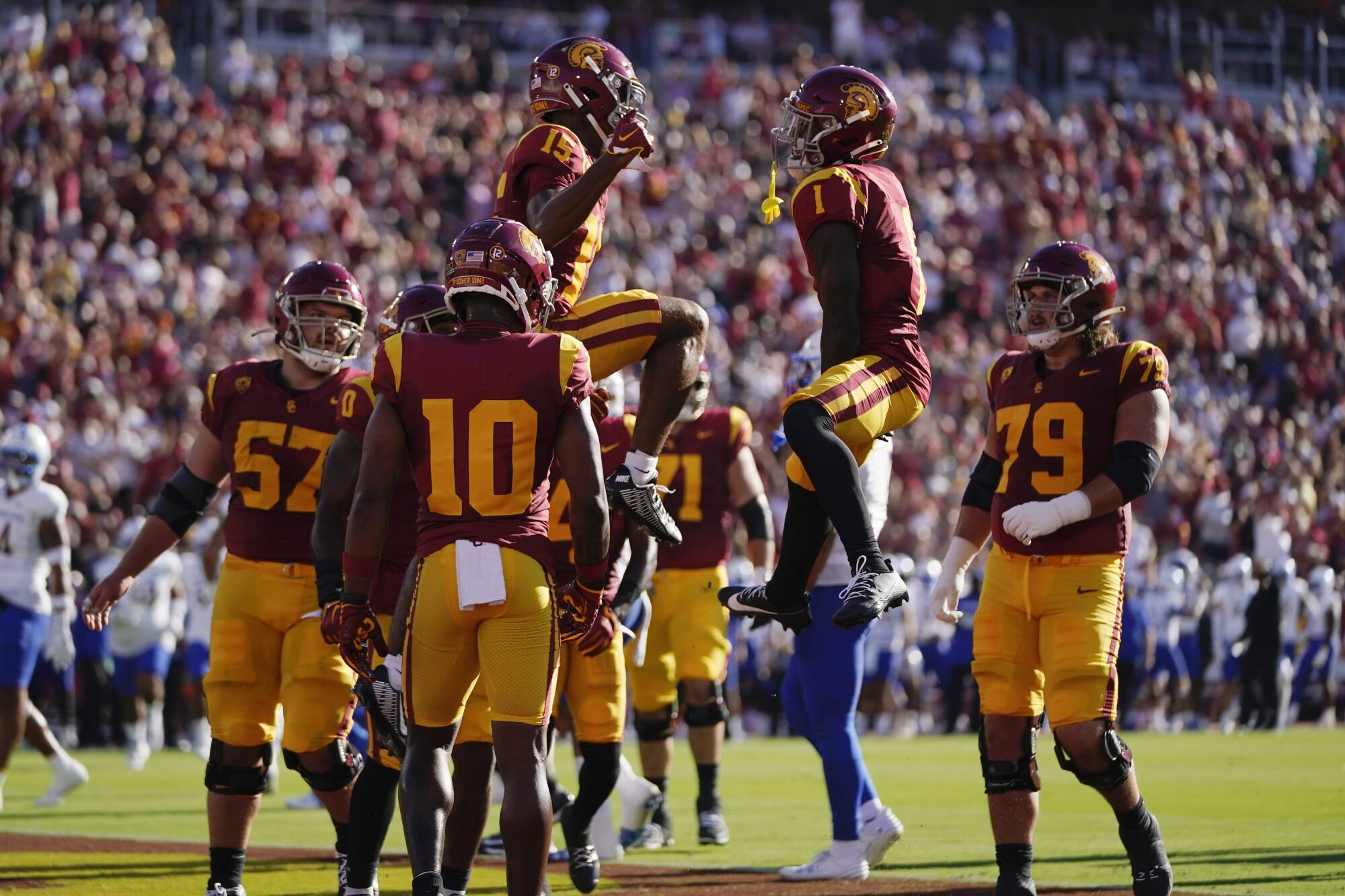 Receivers Dorian Singer and Zachariah Branch jump in the air while celebrating Singer's touchdown against San José State