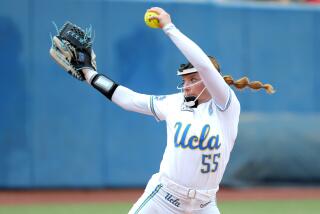UCLA's Kaitlyn Terry (55) pitches during a Women's College World Series softball game.