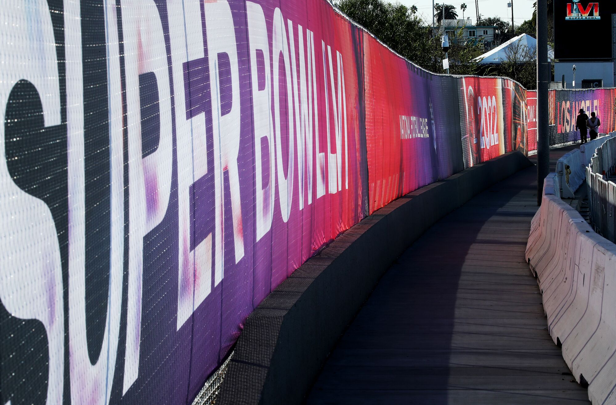 The fence around SoFi Stadium is lined with "Super Bowl LVI" banners.