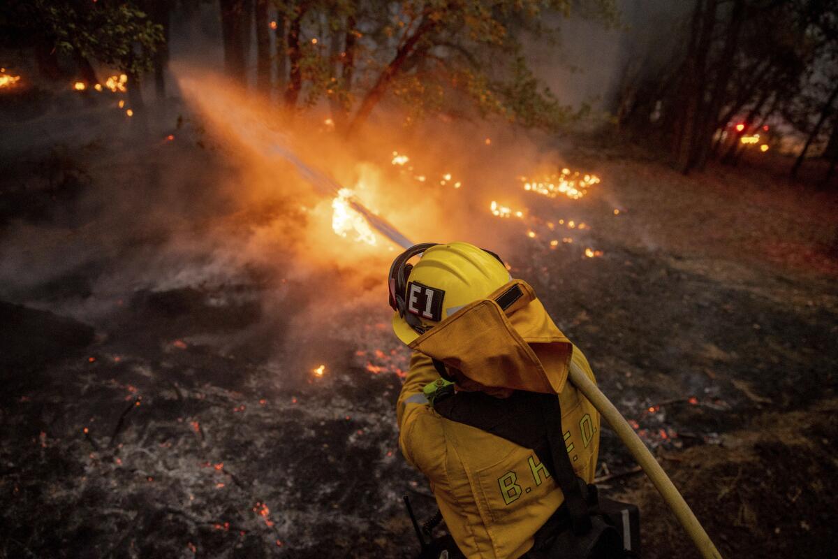 A firefighter battles the Dixie fire in Genesee, Calif., on Saturday.