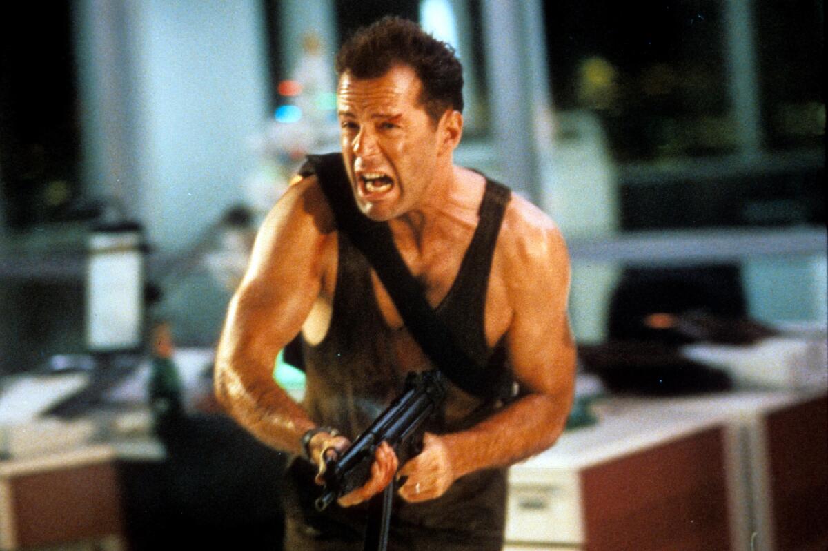 Bruce Willis running with automatic weapon in a scene from the movie “Die Hard” (1988).