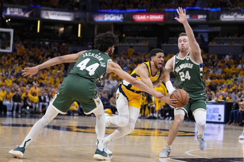 Indiana Pacers guard Tyrese Haliburton (0) drives between Milwaukee Bucks guard Andre Jackson Jr. (44) and guard Pat Connaughton (24) during the second half in Game 2 in an NBA basketball first-round playoff series, Friday, April 26, 2024, in Indianapolis. (AP Photo/Michael Conroy)