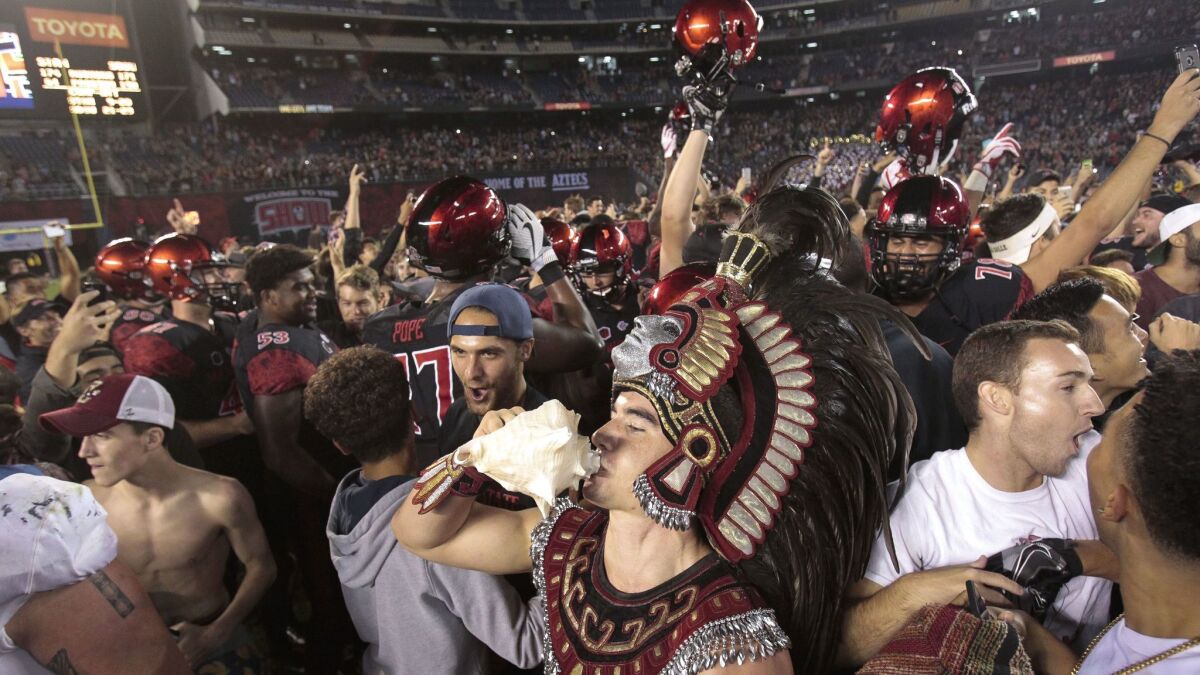 The Aztecs' mascot sounds the couch shell as fans and players celebrate the Aztecs' 20-17 win over Stanford at SDCCU Stadium earlier this month.