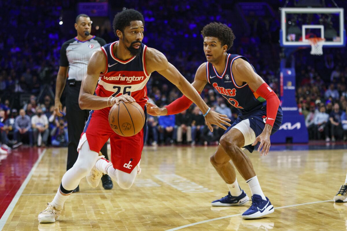 Washington Wizards' Spencer Dinwiddie, left, drives to the basket against Philadelphia 76ers' Matisse Thybulle, right, during the first half of an NBA basketball game, Wednesday, Feb. 2, 2022, in Philadelphia. (AP Photo/Chris Szagola)