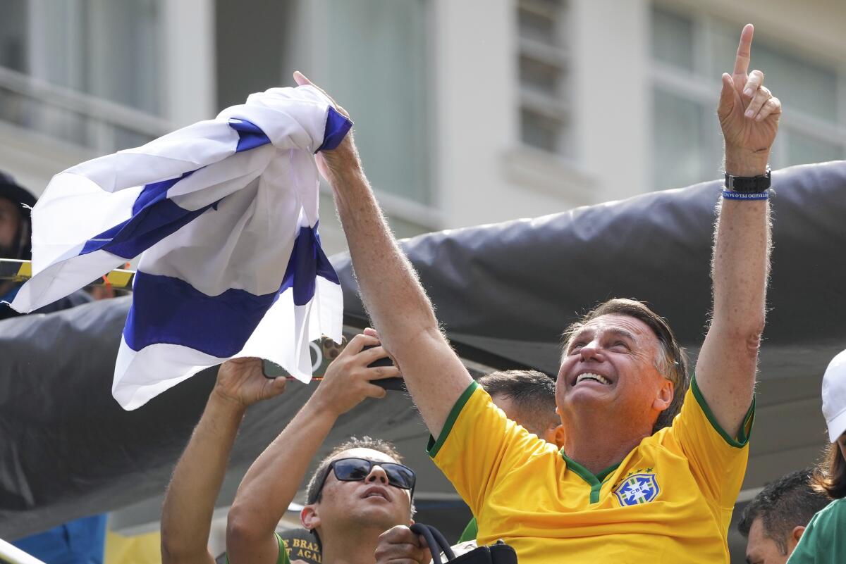 El expresidente brasileño Jair Bolsonaro alza los brazos ante sus simpatizantes durante 