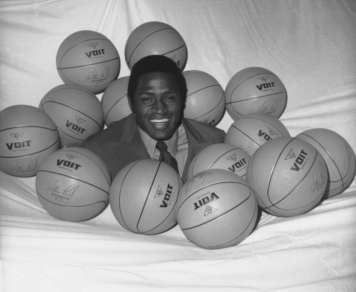 ARCHIVO - Willis Reed, jugador de los Knicks de Nueva York, posa rodeado de pelotas de baloncesto en 1970.