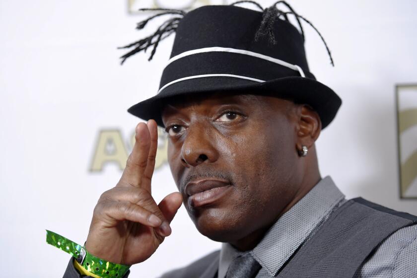 Rapper Coolio gestures with his hand next to his face