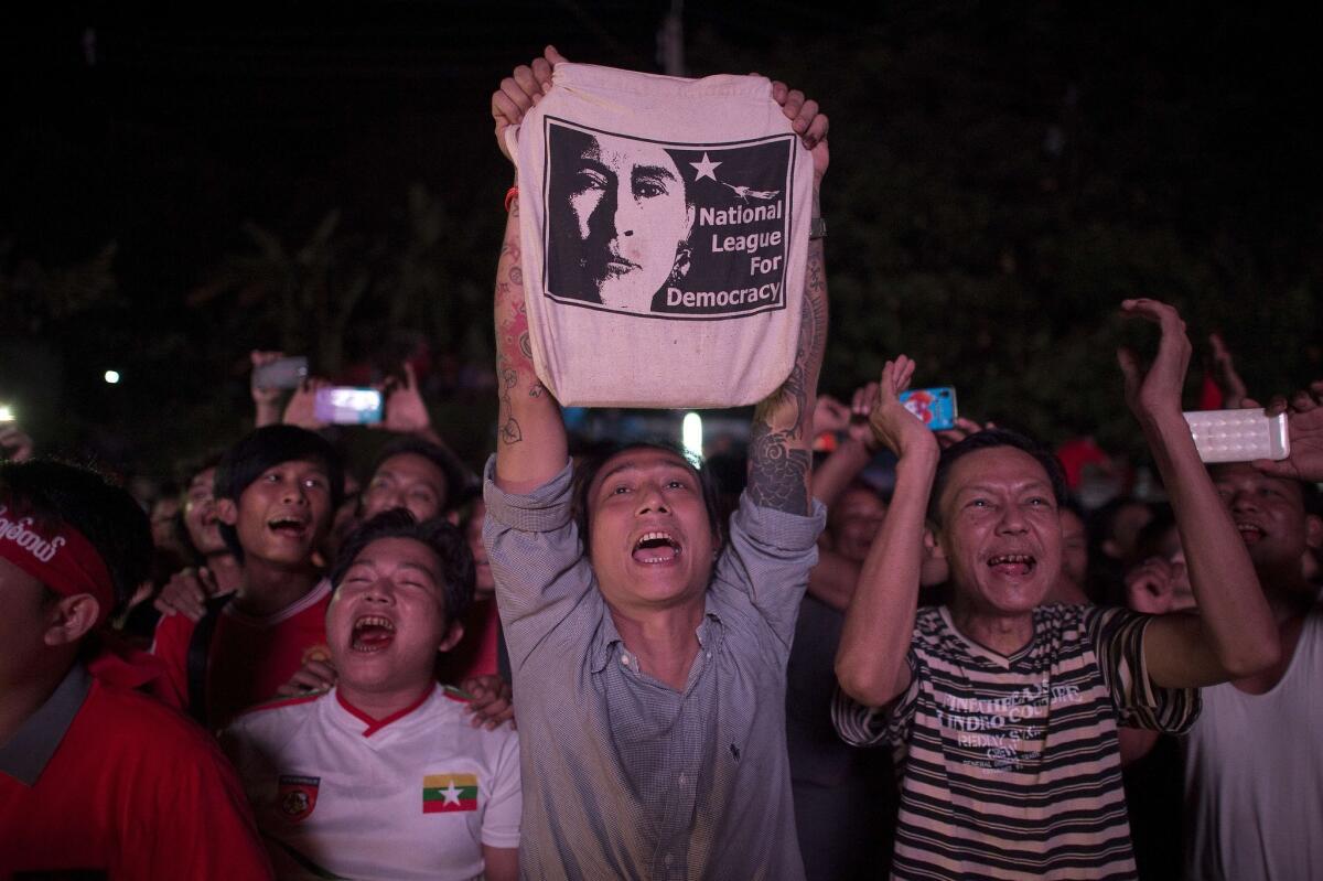 Supporters of Myanmar opposition leader Aung San Suu Kyi celebrate as they look at official results of the elections outside the National League of Democracy headquarters in Yangon on Nov. 9.