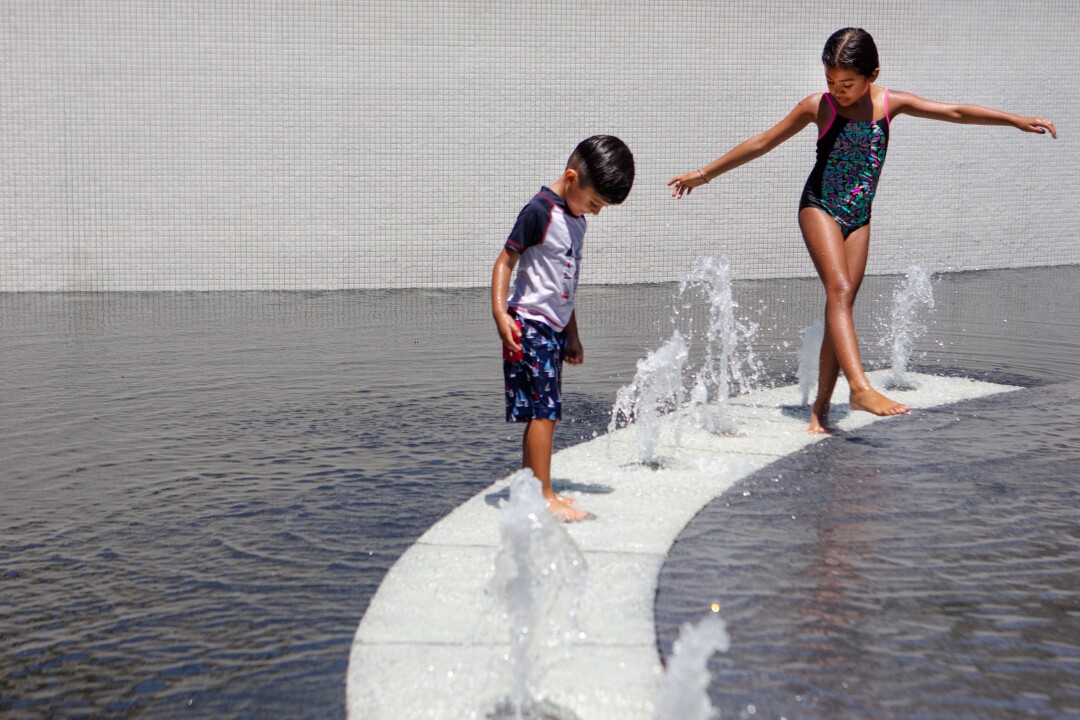 Two children play in the Grand Park fountain.