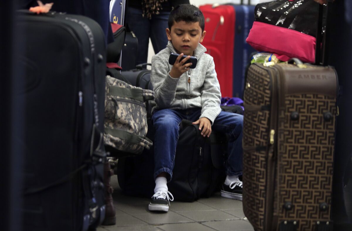 Michael Barrientos, 6, watches YouTube videos while waiting with his family for a flight at LAX last Thanksgiving. The airport is upgrading its free Wi-Fi Internet service to make downloading videos faster.