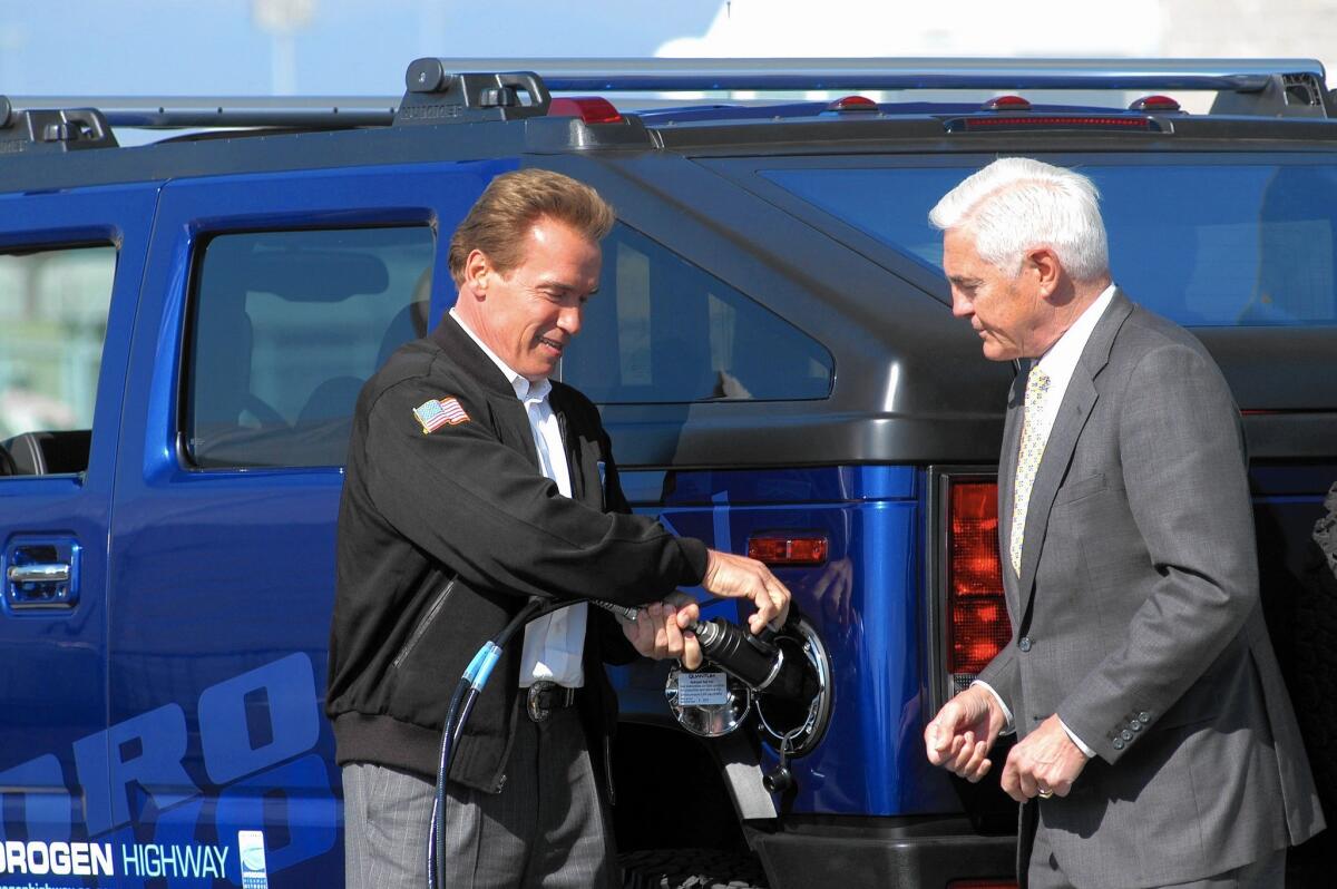 Former Gov. Arnold Schwarzenegger fills up the first hydrogen-powered Hummer in 2004 as then-GM Chairman Bob Lutz looks on at a hydrogen fueling station at Los Angeles International Airport.