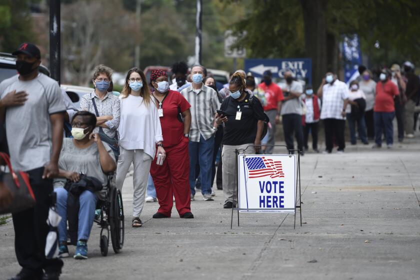 Monday was the first day for advance voting in Georgia and people showed up by the hundreds to cast their ballot early at the Bell Auditorium in Augusta, Ga., Monday, Oct. 12, 2020 (Michael Holahan/The Augusta Chronicle via AP)