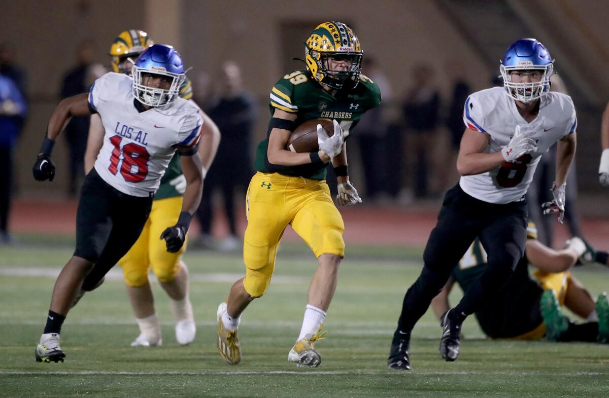 Edison's Carter Hogue (39) runs up the field past through a pack of Los Alamitos tacklers.