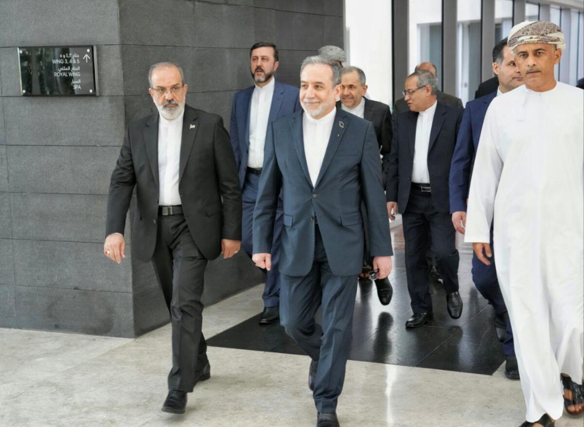 Iranian Foreign Minister Abbas Araghchi heads to venue for talks with several men around him