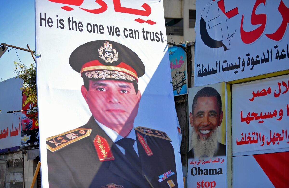 Posters in Cairo show Egypt's army chief General Abdel Fattah Sisi, left, and President Obama with a beard and bearing a slogan referring to the belief by some Egyptians that the U.S. supports the Muslim Brotherhood and the country's ousted president Mohamed Morsi.