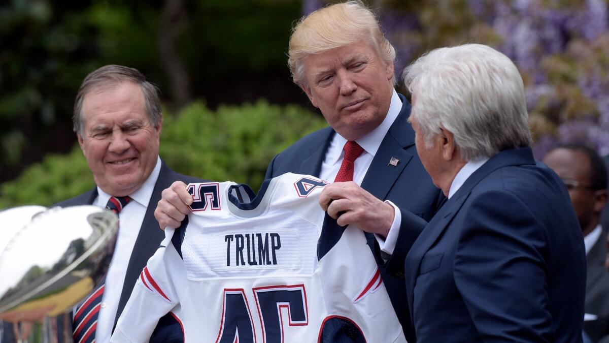 President Trump is presented with a New England Patriots jersey by team owner Robert Kraft, right, and head coach Bill Belichick during the team's visit to the White House in April to honor their Super Bowl championship.