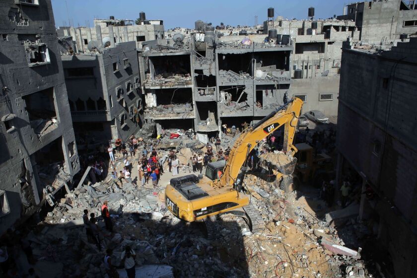 Palestinian emergency personnel dig through the rubble of a building destroyed on Aug. 21 by an Israeli airstrike in Rafah in the southern Gaza Strip.