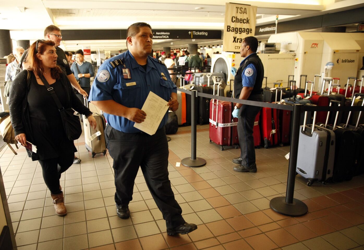 Transportation Security Administration agents help travelers with their luggage. Suspect Paul Anthony Ciancia's family family notified Los Angeles police Friday morning after receiving text messages from the 23-year-old that made them concerned about his well-being.