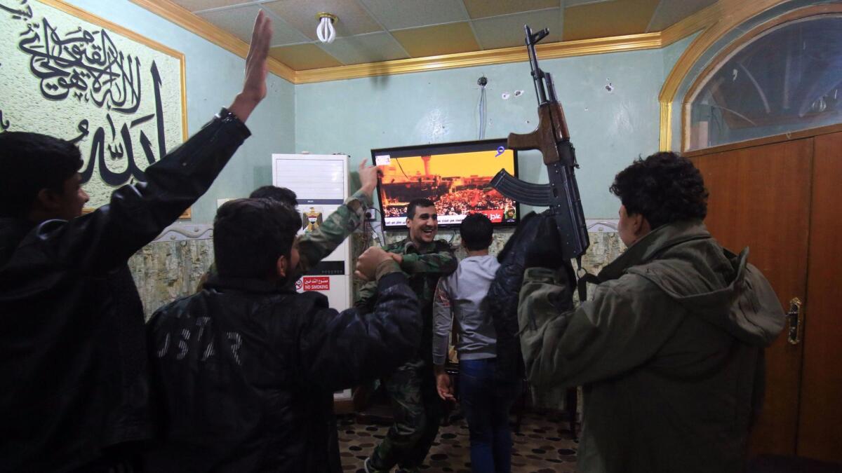 Members of the Hashd al Shaabi (Popular Mobilization Forces) watch the televised statement of Iraqi Prime Minister Haider Abadi in the southern city of Basra. Abadi declared victory in a three-year war by Iraqi forces to expel Islamic State.