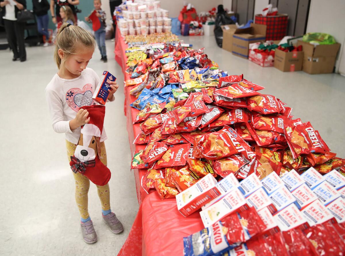Teagan Noonan, 6, helps fill stockings during YMCA of Orange County's "Stockings for Troops."