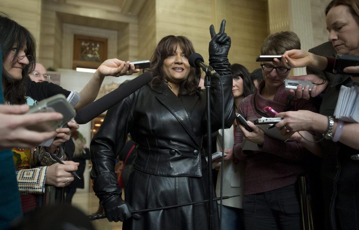 Terri Jean Bedford, in dominatrix garb, flashes a victory sign at the Supreme Court of Canada on Friday after the justices ruled unanimously to strike down laws against prostitution. Bedford and other sex workers argued that the laws constitute arbitrary discrimination and prevent them from practicing their trade safely.