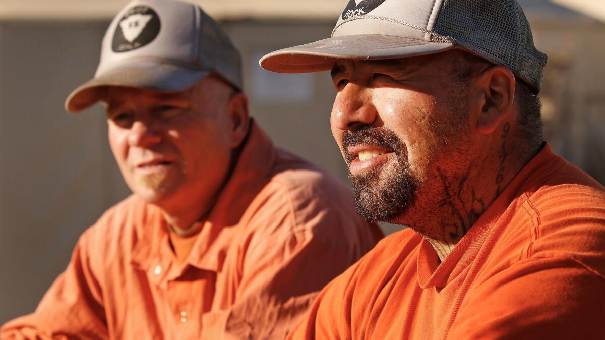Inmates Gerardo Moran, right, and Lanny Mosley talk about their experiences working on a fire crew while resting between shifts.