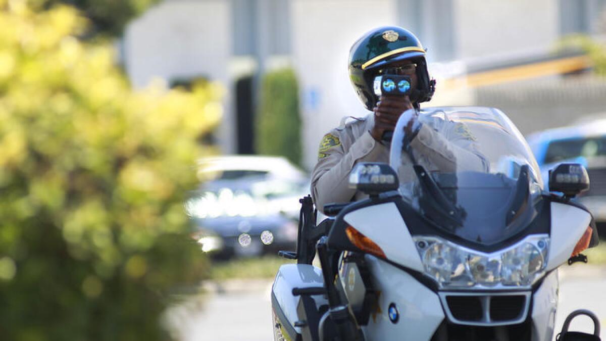 El agente del Sheriff de Los Ángeles, Elton Simmons, apunta su pistola de medición de velocidad hacia un automovilista en La Mirada el pasado junio del 2012.