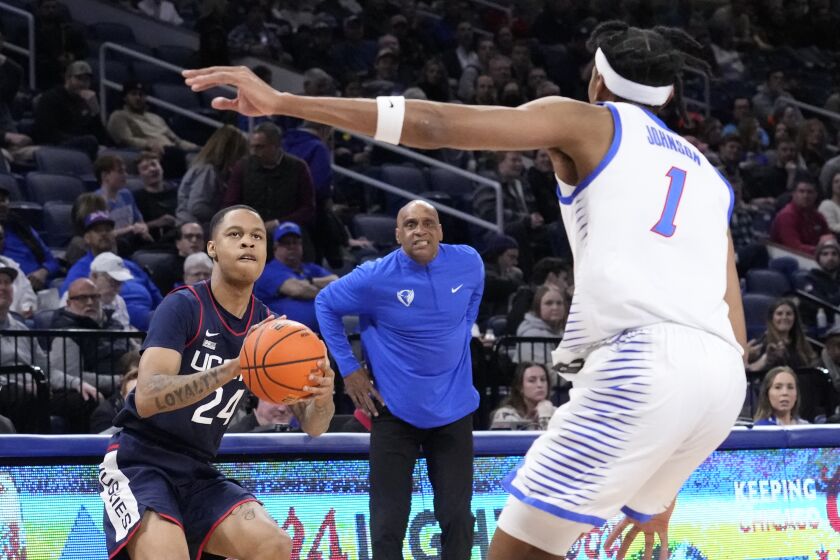 Connecticut's Jordan Hawkins (24) eyes the basket as DePaul head coach Tony Stubblefield and Javan Johnson watch during the first half of an NCAA college basketball game Tuesday, Jan. 31, 2023, in Chicago. (AP Photo/Charles Rex Arbogast)