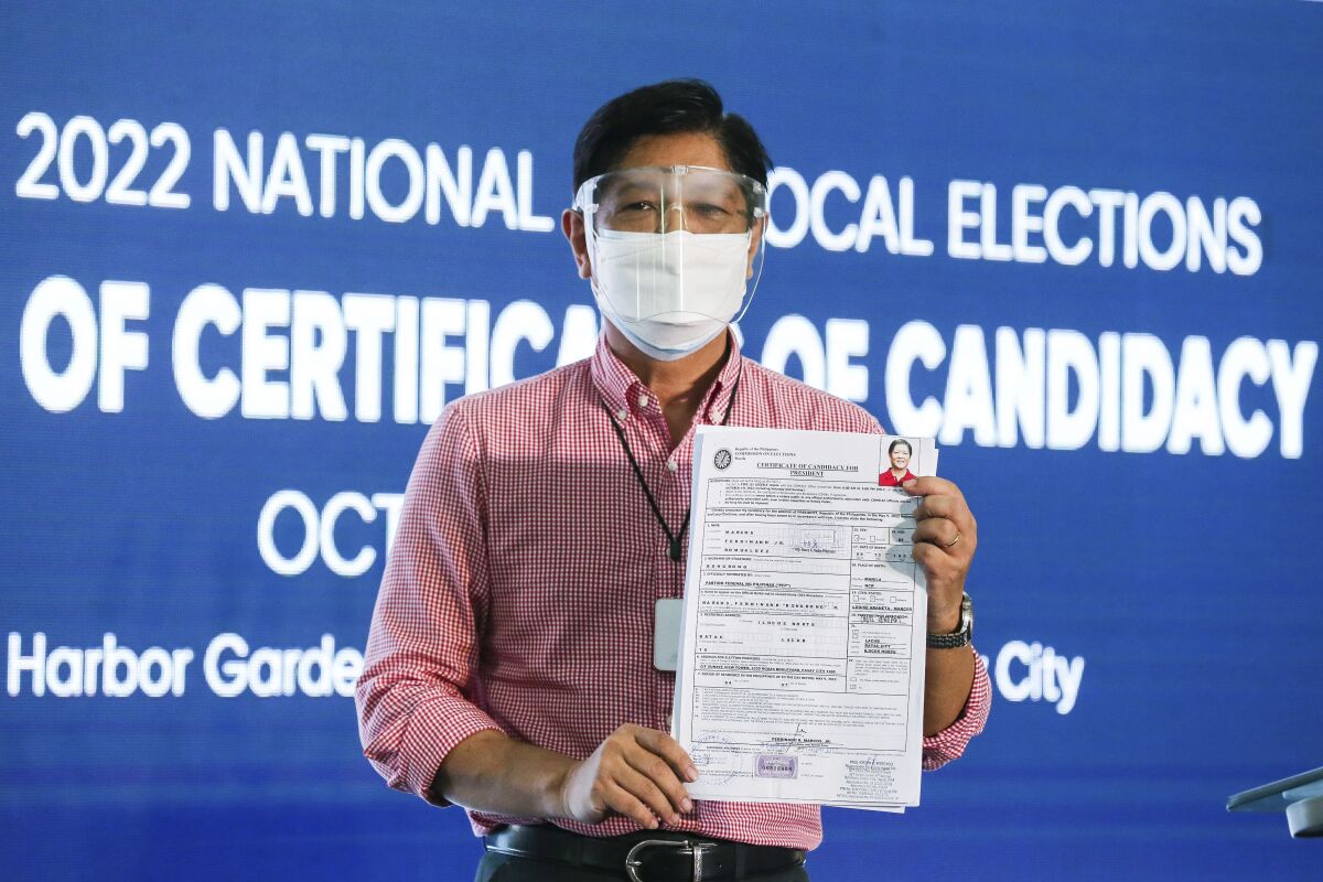 Former senator Ferdinand "Bongbong" Marcos Jr. poses after filing his certificate of candidacy for next year's presidential elections with the Commission on Elections at the Sofitel Harbor Garden Tent in Manila, Philippines Wednesday, Oct. 6, 2021. The son of former Philippine dictator Ferdinand Marcos defeated on Monday, Jan. 17, 2022 a bid to disqualify him from the May 9 presidential race but still faces other petitions from human rights victims and others who have raised alarm over atrocities under his late father's rule. (Rouelle Umali/Pool Photo via AP, FILE)