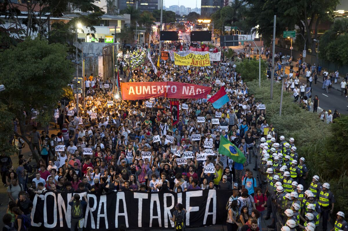 Demonstrators in Sao Paulo, Brazil, carry banners that read in Portuguese "Against the Fare" and "No Rise" during a protest against the bus fare increase.
