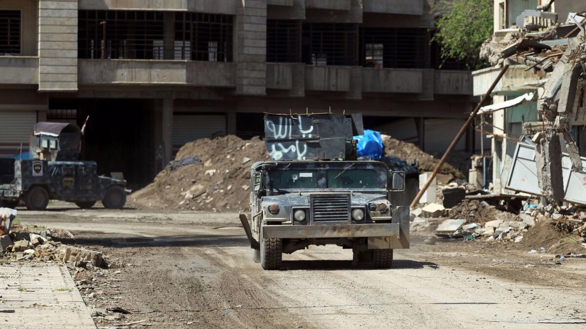 Iraqi forces drive down a street in the old city of Mosul on April 15, 2017.