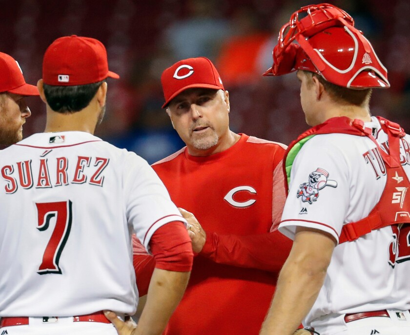 Cincinnati Reds manager Bryan Price (center) waits on the mound while making a pitching change.