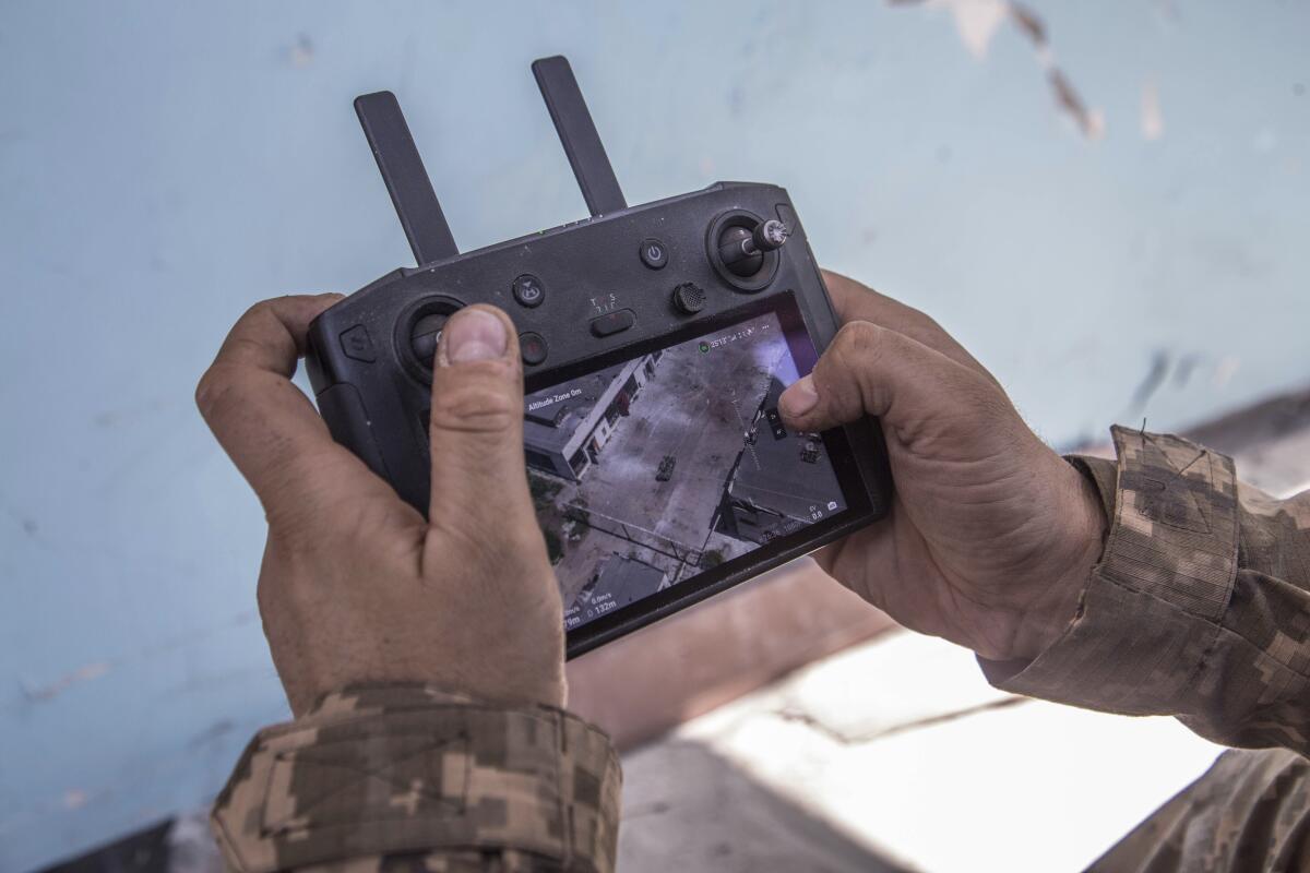 Ukrainian soldier's hands holding a drone screen
