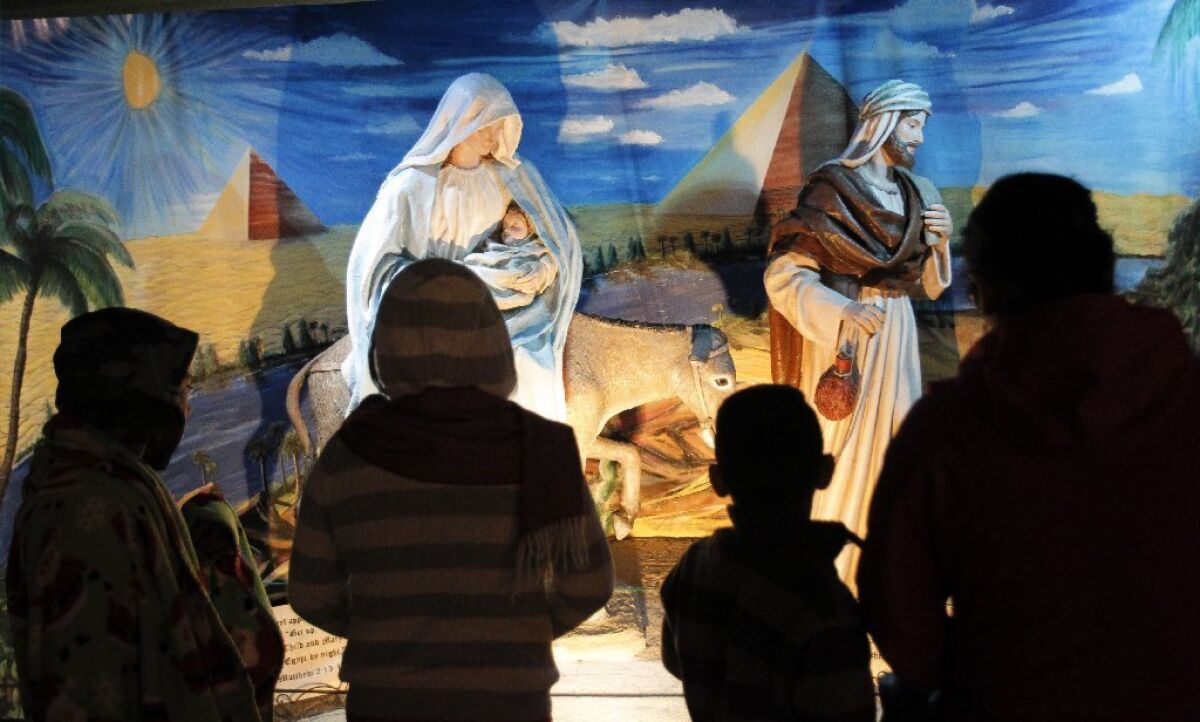 People look at the restored Nativity display during December Nights at Balboa Park in San Diego.