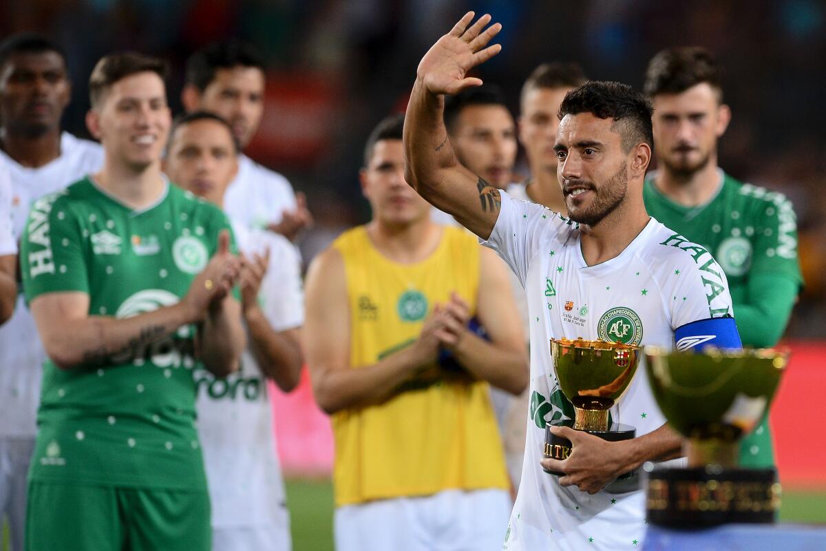 Chapecoense's defender Alan Ruschel waves to Barcelona players as he holds the second place trophy after the 52nd Joan Gamper Trophy friendly football match between Barcelona FC and Chapecoense at the Camp Nou stadium in Barcelona on August 7, 2017. / AFP PHOTO / Josep LAGOJOSEP LAGO/AFP/Getty Images