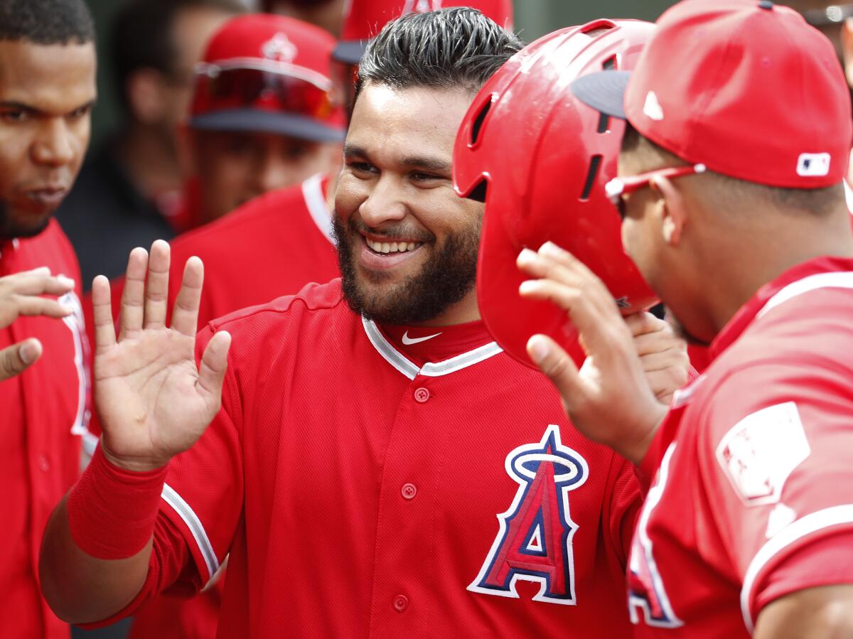 Angels' Jose Rojas high-fives teammates after scoring on a double by Wilfredo Tovar.