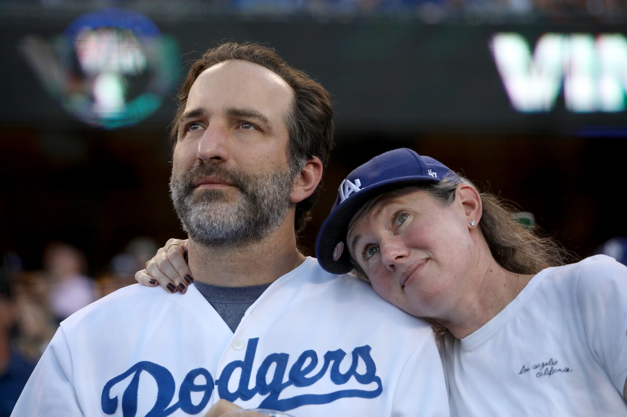 I fan dei Dodgers guardano un video in onore della vita di Vin Scully prima della partita di venerdì al Dodger Stadium.