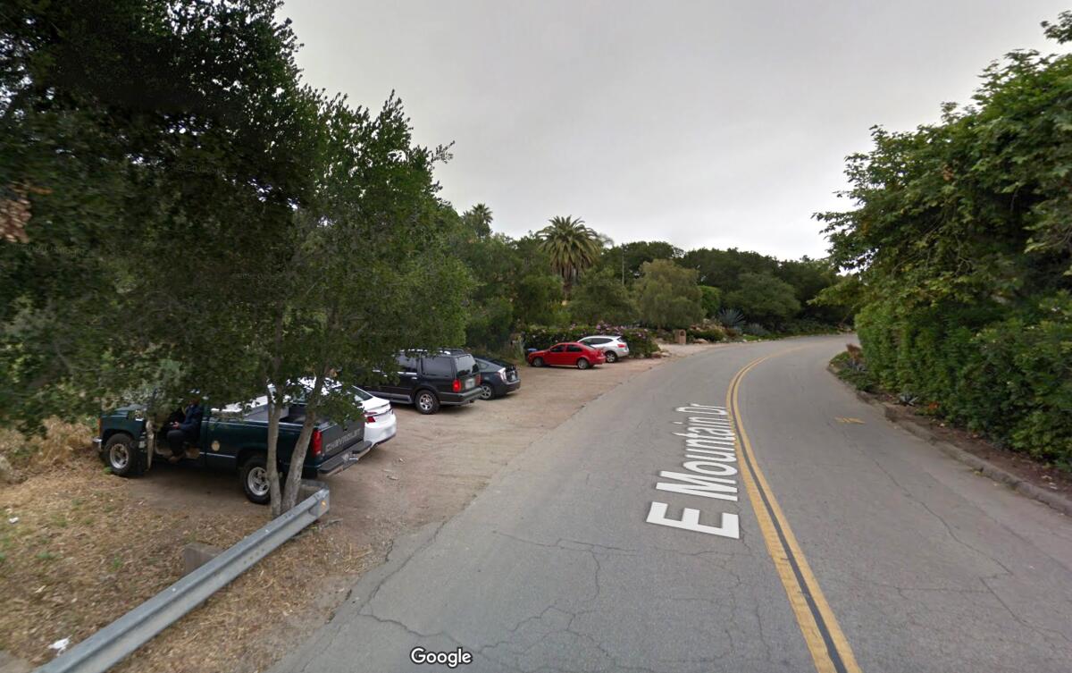 Cars in a small roadside parking lot in a street view from Google Maps.
