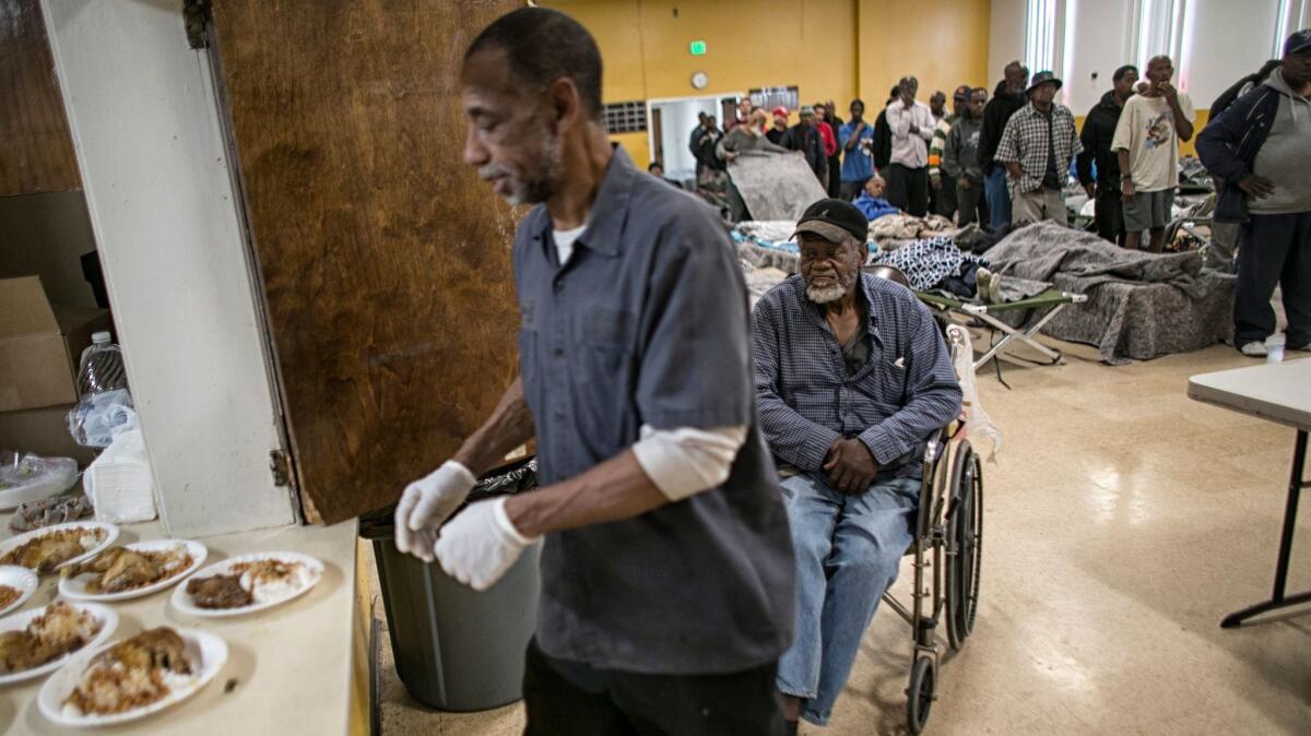 Arthur Reeder, 62, waits for a dinner of chicken, beans and rice served by Willie Brooks at the winter homeless shelter at Bethel AME church.