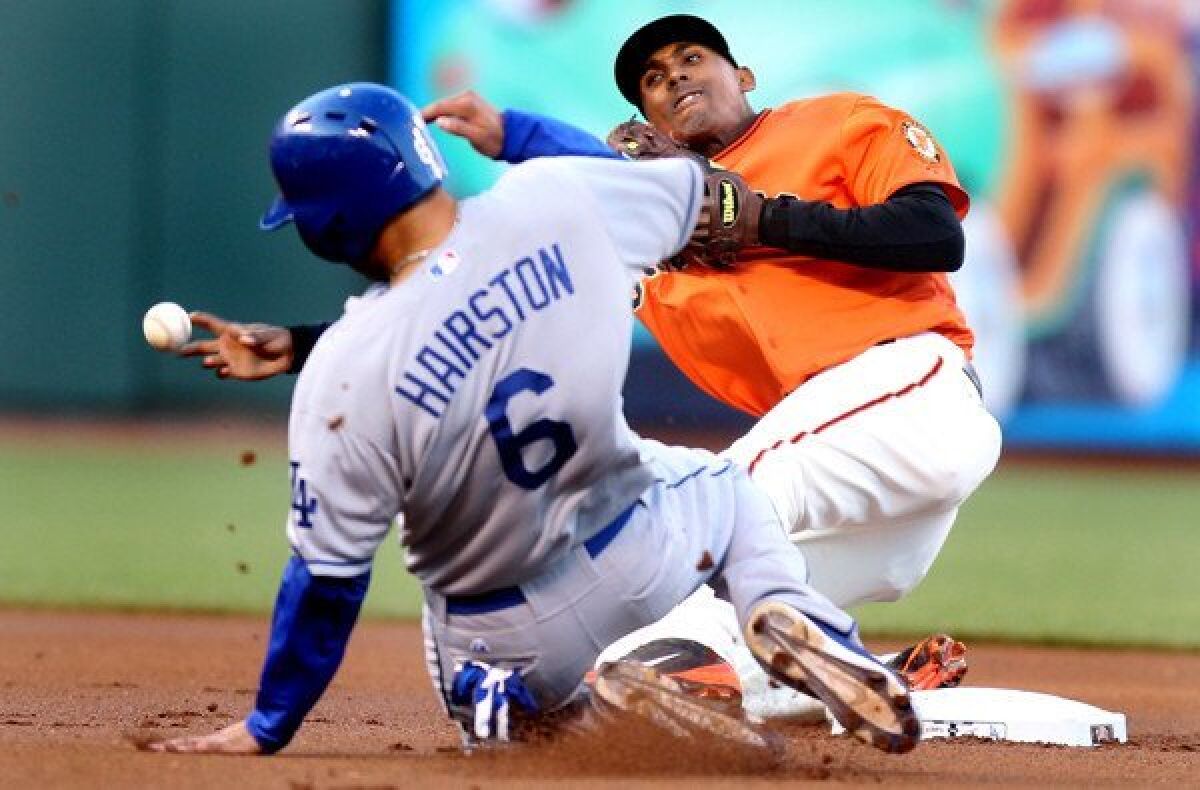 Giants second baseman Joaquin Arias tries to complete a double play as Dodgers first baseman Jerry Hairston Jr. slides into second base during their game Friday night in San Francisco.