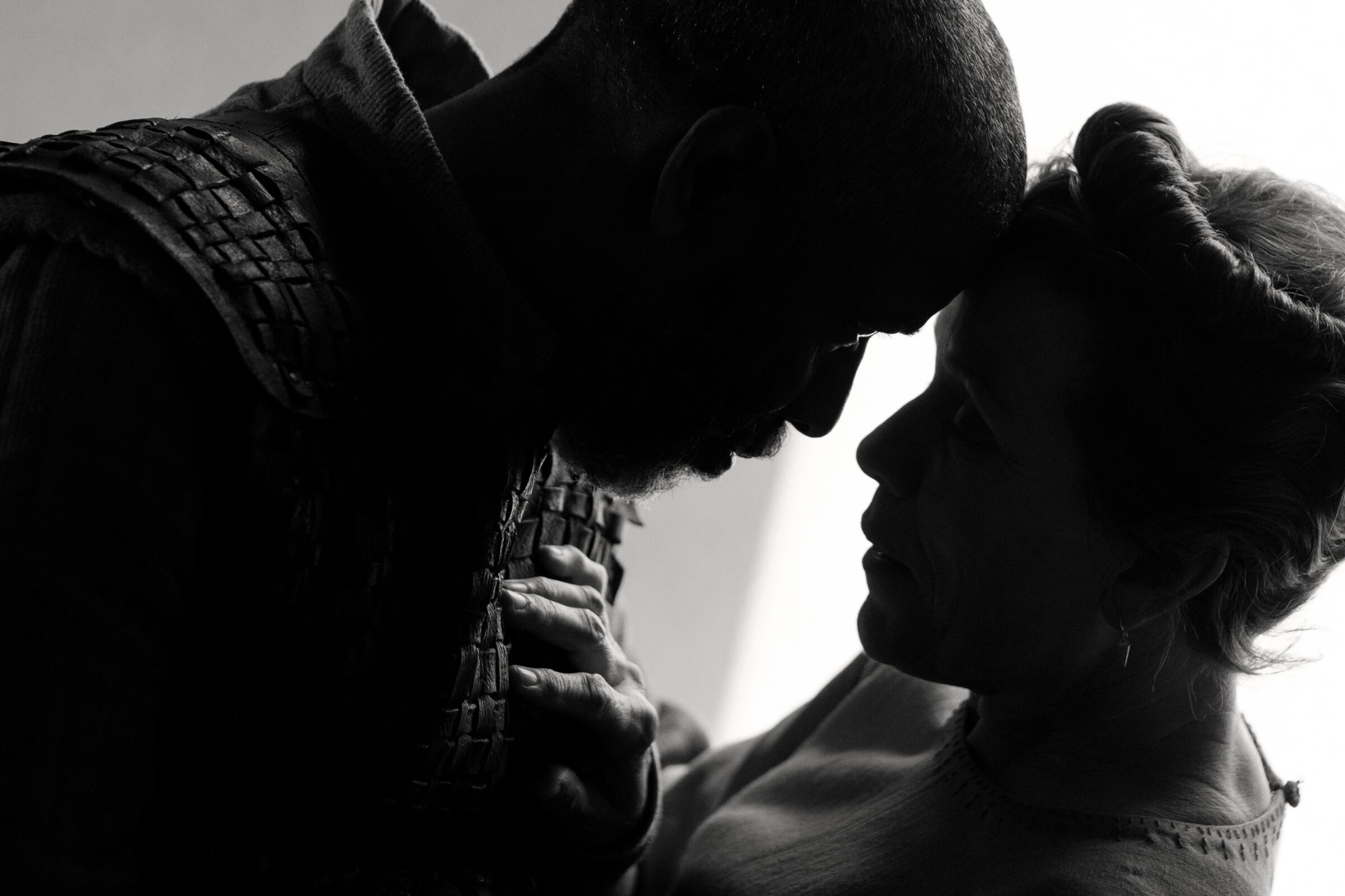 A man and woman in Macbeth clothes touch foreheads