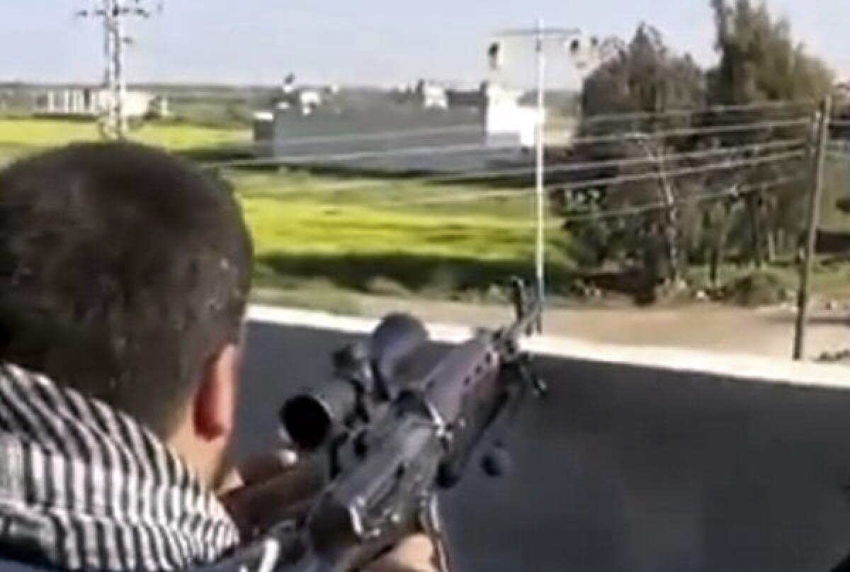 This image taken from video obtained from Ugarit News, which has been authenticated based on its contents and other Associated Press reporting, shows a fighter with the Syrian Free Army firing on a Syrian army position in Dael, near the Jordanian border.