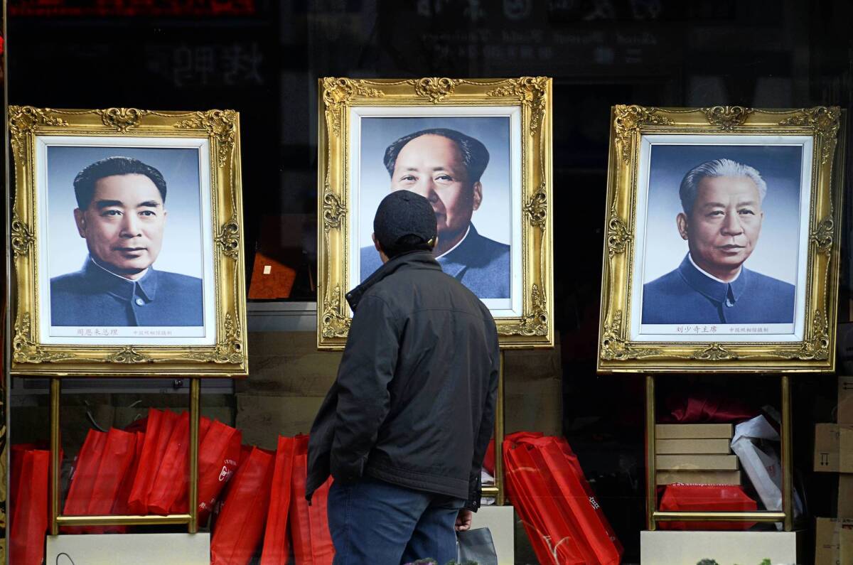 Portraits of late Chinese leaders Chou En-lai, from left, Mao Tse-tung and Liu Shaoqi attract the attention of a passerby in Beijing. China's Communist Party will be announcing its next leaders at its weeklong congress.