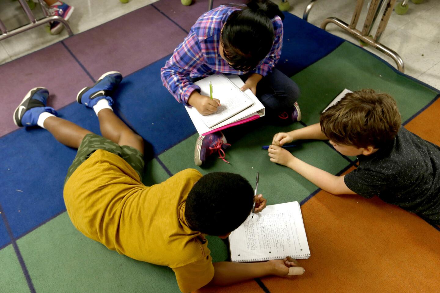 Hector Gray, 9, left, Rachel Asuncion, 10, middle, and Malcolm Rose, 10, right, in class at the gifted magnet program at Eagle Rock Elementary School in Los Angeles.